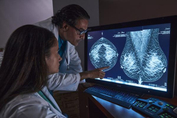 Radiologistas a analisar exame de tomossíntese mamária no ecrã