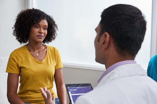 Mulher a conversar com o médico no consultório