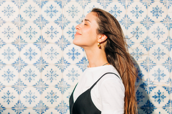 Mulher sorridente, a olhar para o lado, num dia solarengo