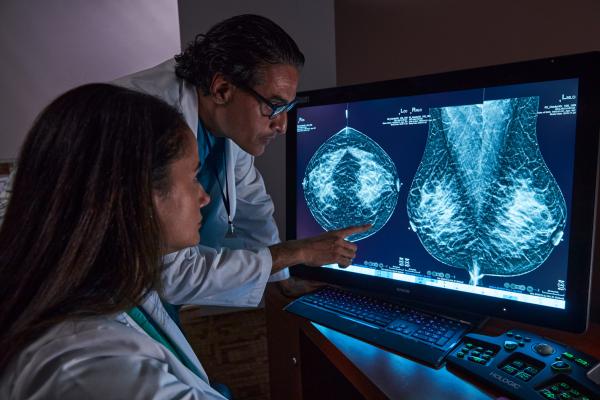 Radiologistas a analisar exame de tomossíntese mamária no ecrã