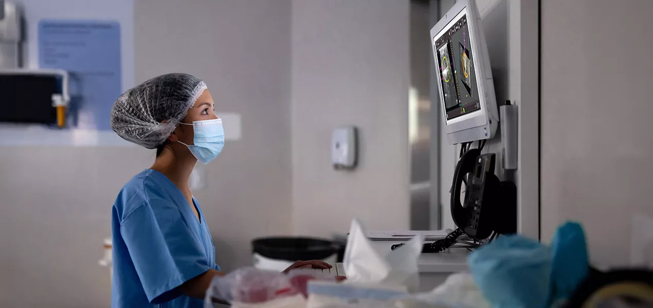 Profissional de saúde a olhar para um ecrã no laboratório
