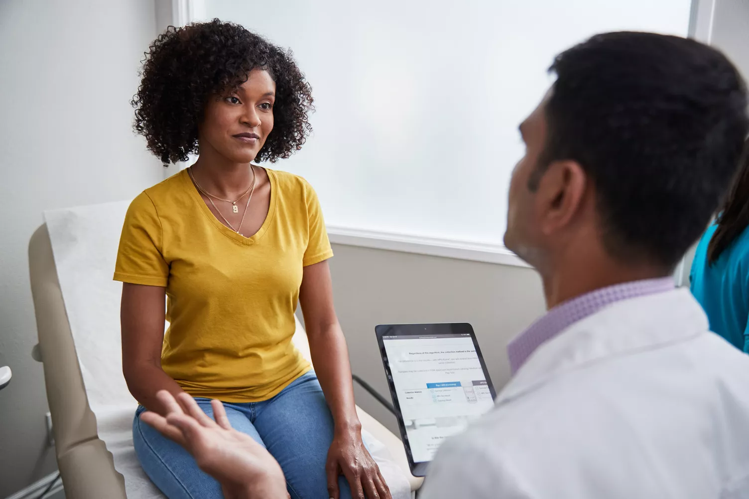 Médico a falar com a paciente no consultório médico.