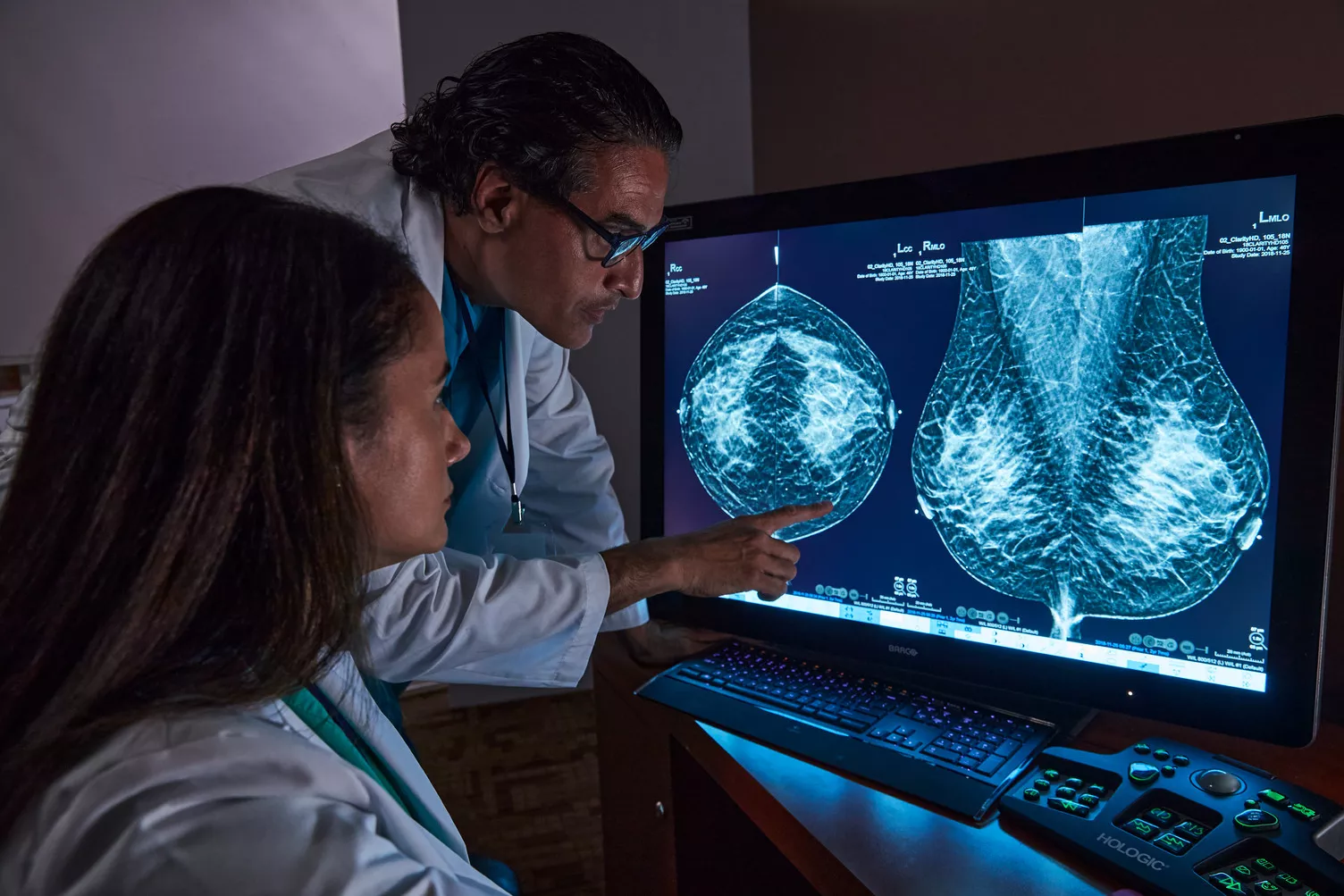 Radiologistas a analisar exame de tomossíntese mamária no ecrã