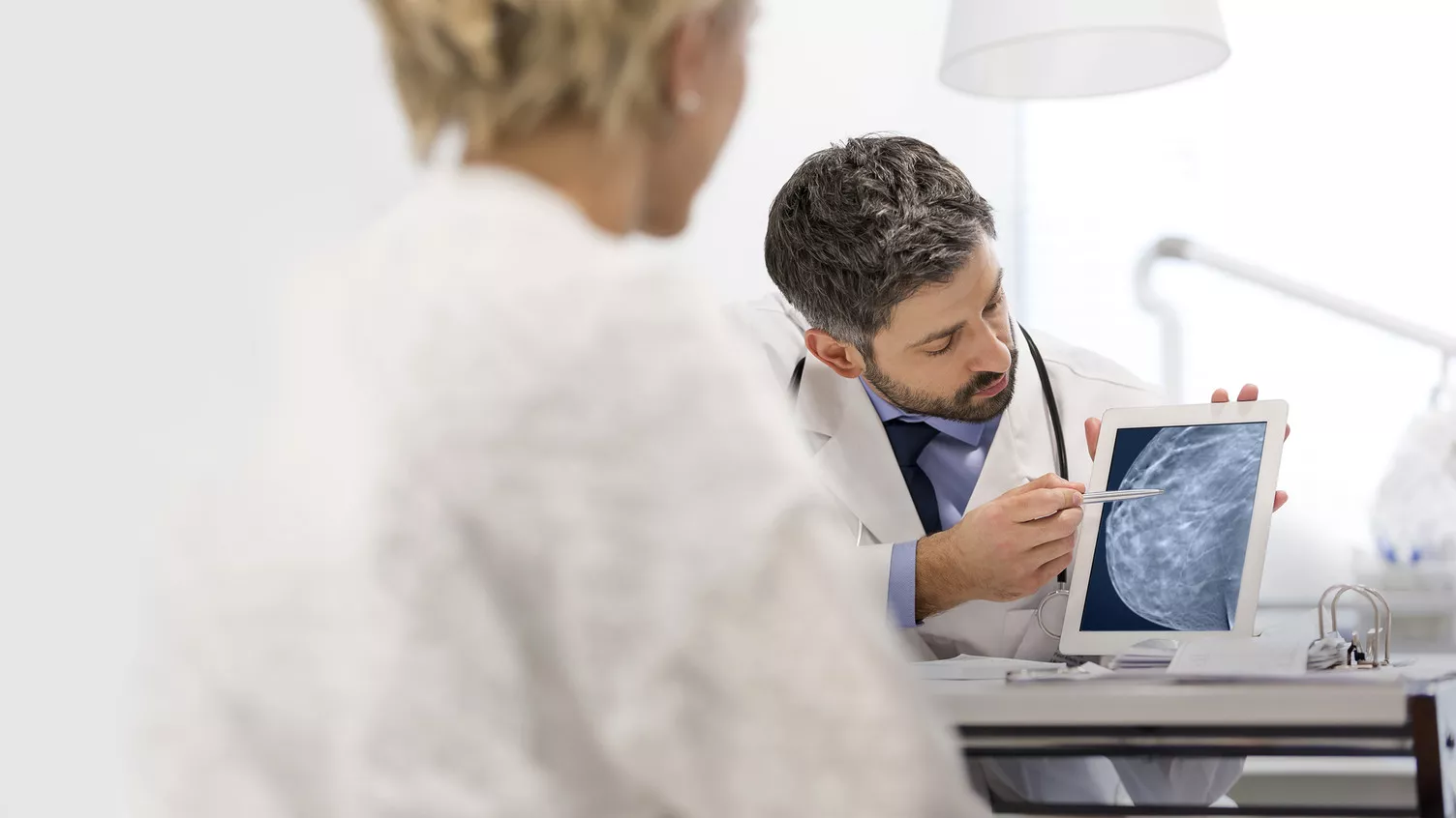 Radiologista a mostrar no tablet uma mamografia