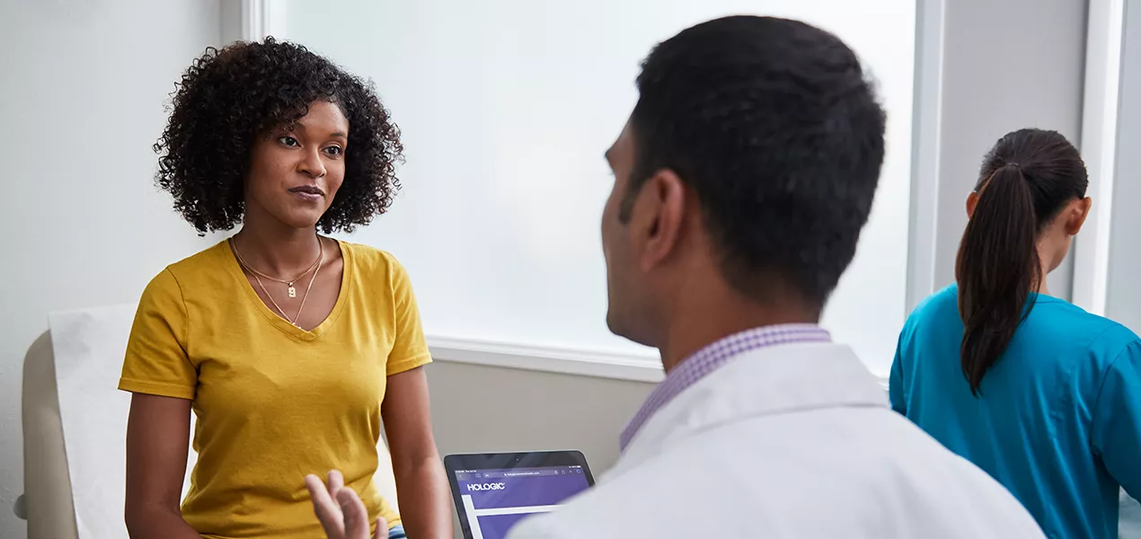 Mulher a conversar com o médico no consultório