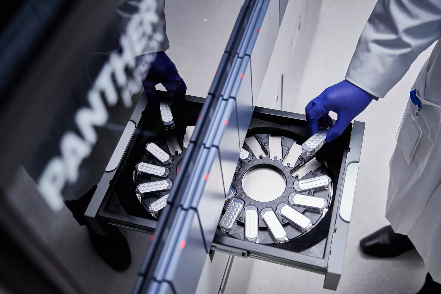 Técnico de laboratório a colocar um cartucho no instrumento Panther Fusion