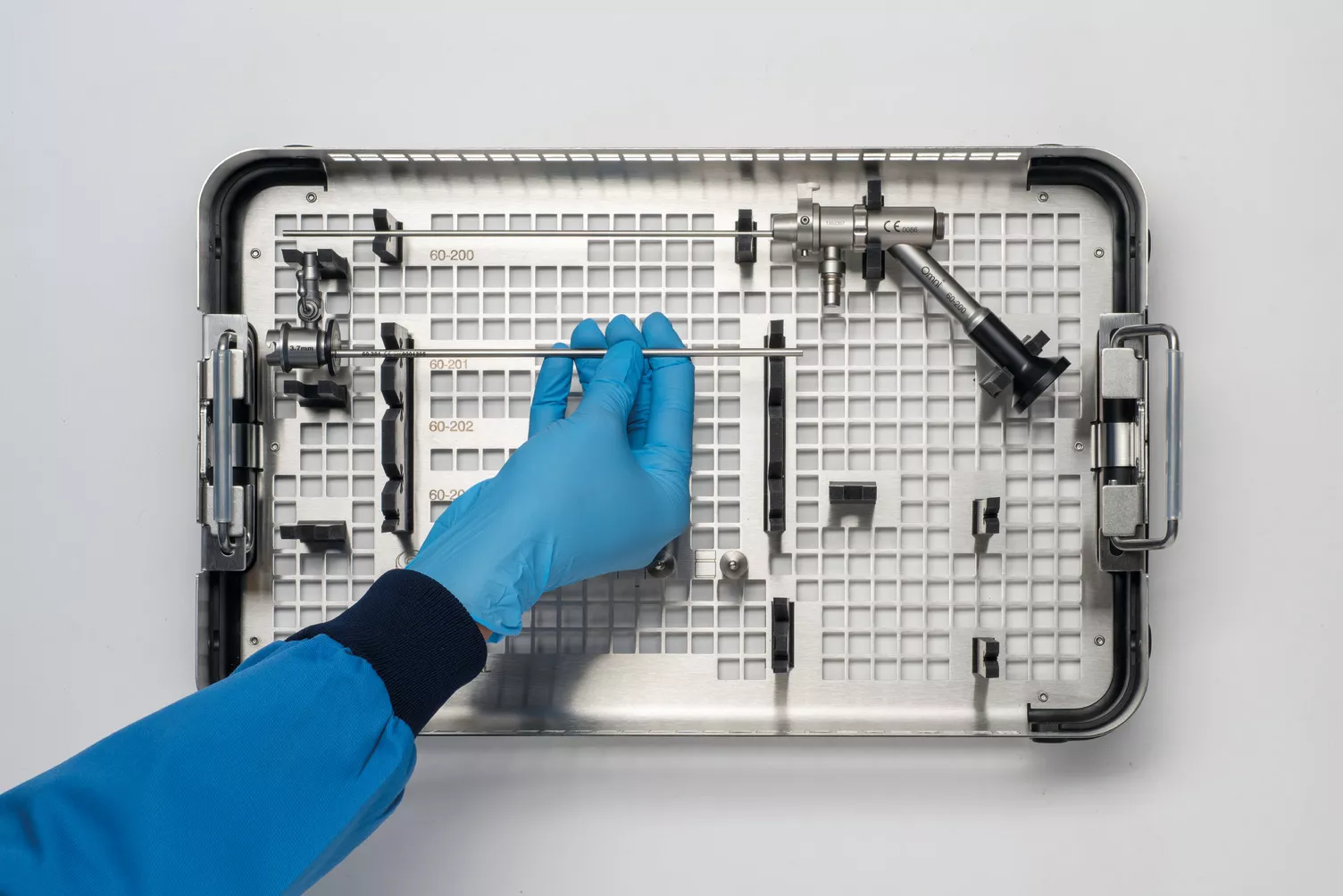 Pessoa com luvas a segurar o tabuleiro médico na mesa.