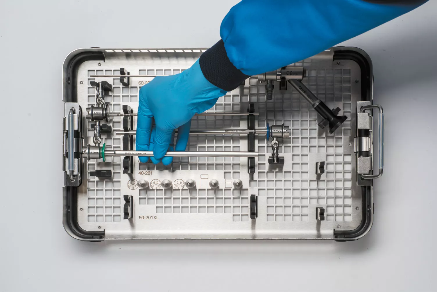 Pessoa com luvas a segurar o tabuleiro médico na mesa.