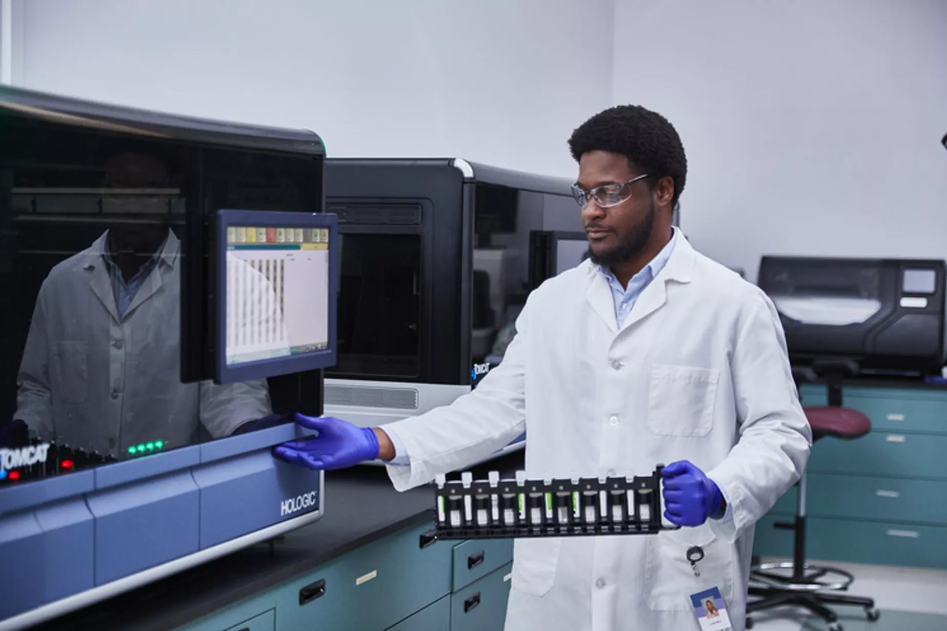 Técnico a segurar um tabuleiro com tubos no laboratório
