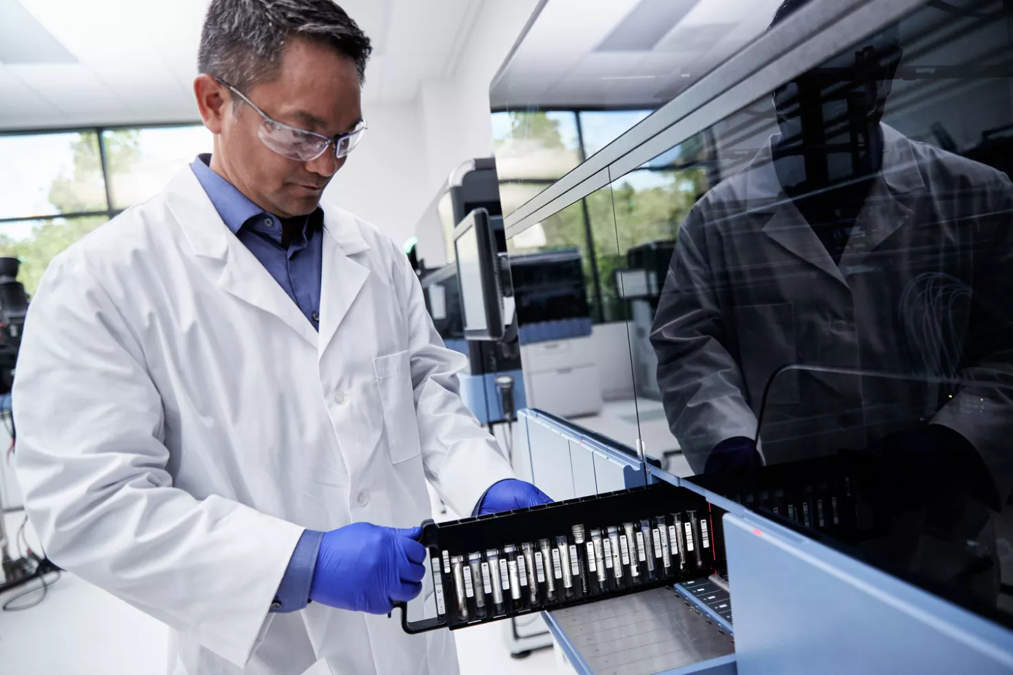 Técnico de laboratório a colocar tubos de teste no equipamento